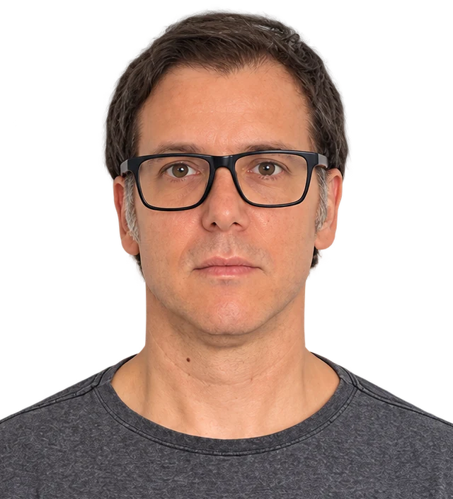 Marcus Rodrigues facing the camera, wearing black-framed glasses and a grey T-shirt.